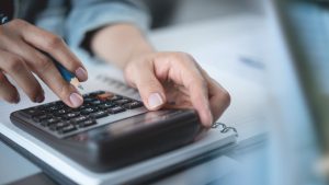 Pessoa usando calculadora, em referência ao imposto sobre grandes fortunas no Brasil